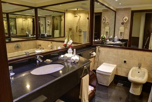 拉合尔拉合尔五洲明珠大酒店的一间带水槽、卫生间和镜子的浴室