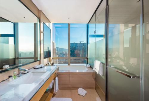 深圳深圳福田温德姆至尊酒店的带浴缸的浴室和大窗户