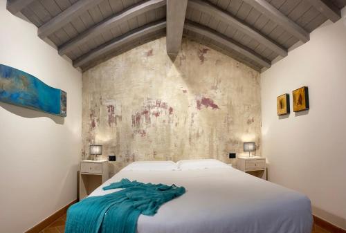 彼得拉桑塔Dimora Carducci的卧室配有白色的床和墙壁