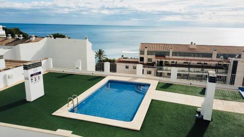 阿尔啼Apartamento Altea Blanca的一座位于一座海洋房子屋顶上的游泳池