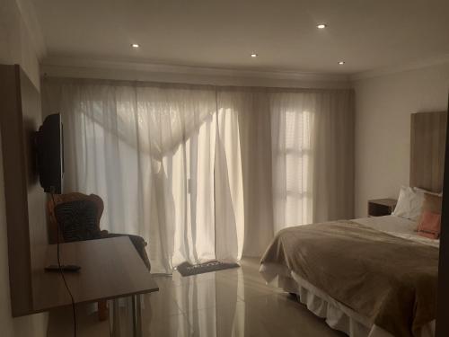 KwamhlangaLesiba guesthouse的一间卧室设有一张床和一个大窗户