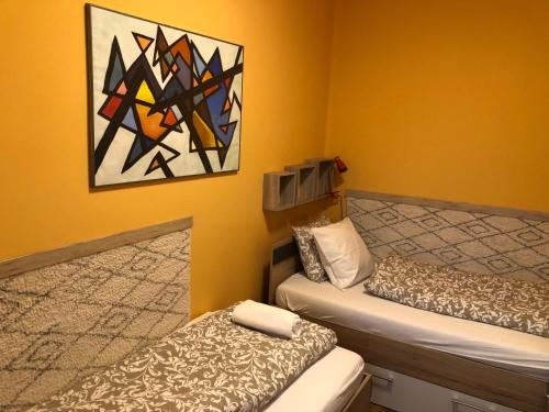 迈泽克韦什德Galéria deluxe apartman的一间设有两张床的客房,墙上挂着一幅画