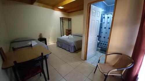 圣佩德罗·德·阿塔卡马La Tribu del Indio的一间带一张床和一张桌子的房间以及一间带一间卧室的房间