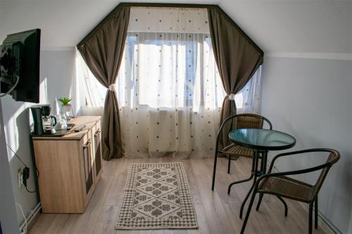 上维谢乌Casa Mocanitei的客房设有桌椅和窗户。