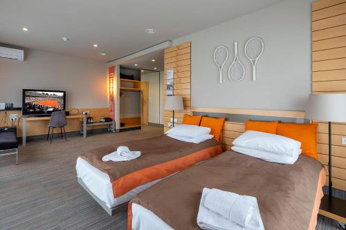 波兹南Hotel Restauracja Tenis Kortowo的一间酒店客房,设有两张床和电视