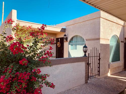 土桑Central French Charm in Tucson的一座满是红色花卉和围栏的房子