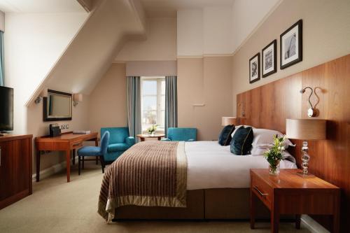 约克The Grand, York的酒店客房,配有一张床、一张桌子和椅子