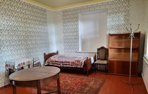 LichkʼThe Lichk Lodge的卧室配有1张床、1张桌子和1把椅子
