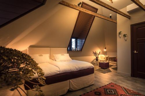 LuttenbergHet Spijkerhuys的一间卧室设有一张床和一个大窗户