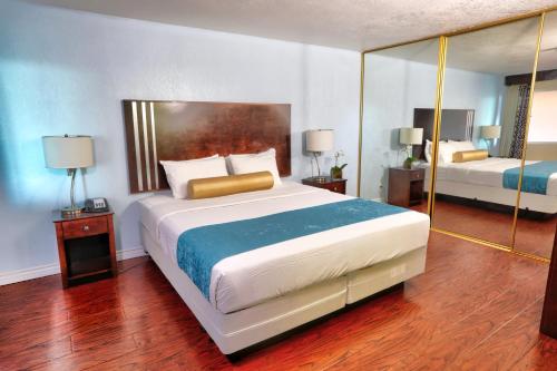 圣地亚哥Sunrise Inn San Diego的一间卧室配有一张大床和镜子