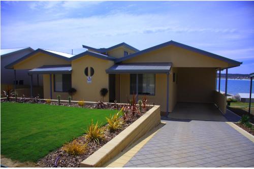 Emu BayBirubi Holiday Homes Kangaroo Island的黄色房子前面有走道