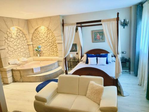 佩多拉卡斯蒂略博纳维亚酒店的一间带浴缸、一张床和一张沙发的卧室