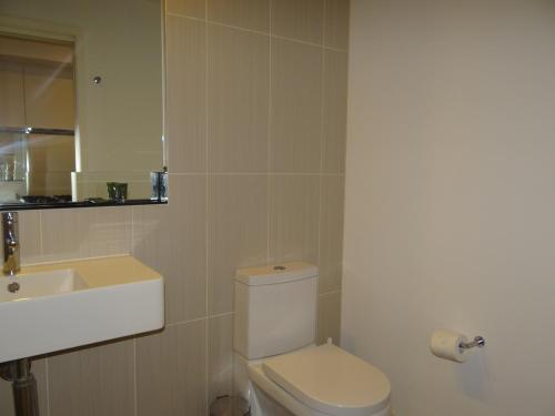 墨尔本美丽公寓：时尚的浴室配有白色卫生间和盥洗盆。