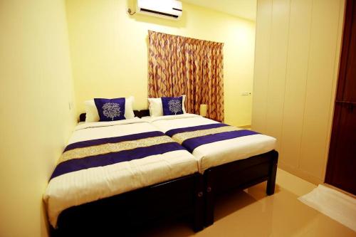 Fort KochiGeo Fort Home - Fortkochi的一间卧室配有一张带蓝白色床单的大床