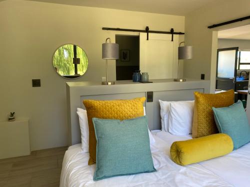 克拉伦斯Kingsbrook Pods的卧室配有白色的床和色彩缤纷的枕头