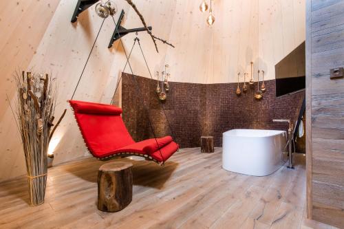 NatternbachIKUNA Naturresort的红色椅子和室内白色浴缸