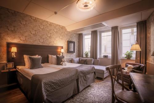 斯德哥尔摩弗雷斯酒店的一间卧室配有一张床、一张沙发和一张桌子