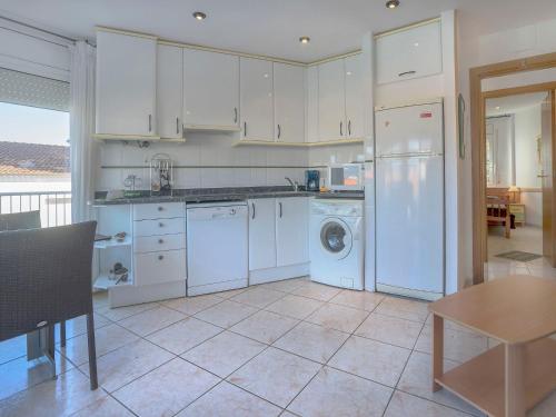 兰卡Apartment Palmiers I-11 by Interhome的厨房配有白色橱柜、洗衣机和烘干机