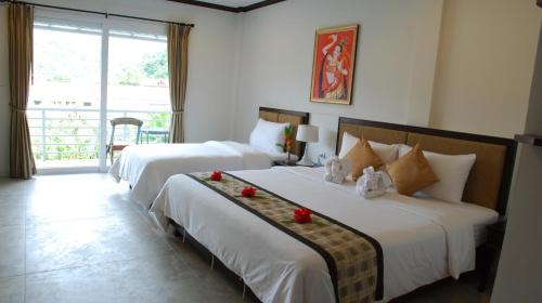 卡马拉海滩普卡玛拉套房式酒店的酒店客房设有两张床和一个阳台。