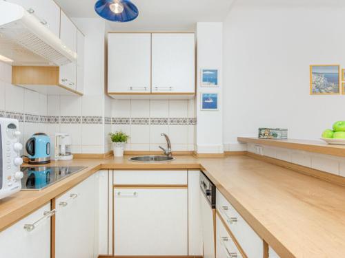 罗萨斯Apartment ROSES 5 by Interhome的厨房配有白色橱柜和木制台面