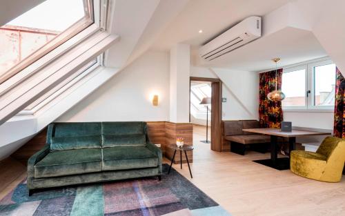 因斯布鲁克扎克酒店的客厅配有绿色沙发和桌子