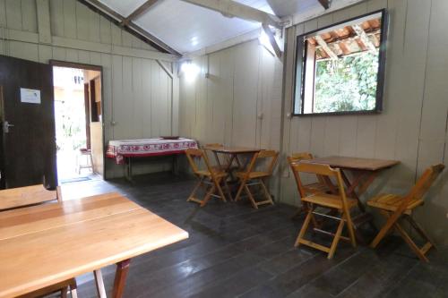 特林达德Pousada Mar Azul的客房设有木桌、椅子和窗户。