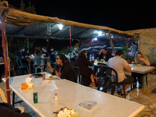 安曼Al Midan Hotel的一群人坐在帐篷下的桌子上