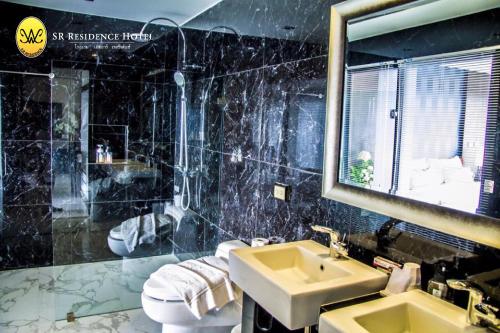 碧差汶SR酒店的一间带水槽、卫生间和镜子的浴室