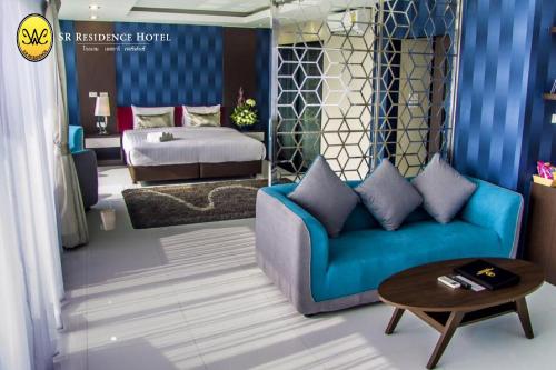 碧差汶SR酒店的客厅配有蓝色的沙发和床。