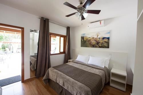 西波山Pousada Cantuá的一间卧室配有一张床和吊扇