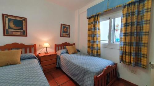 卡索拉Alojamiento Rural Fuente De La Glorieta的一间卧室设有两张床和窗户。