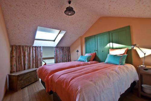 蒙斯拉马洛格住宿加早餐旅馆的一间卧室配有一张大床,提供红色的床单和蓝色的枕头