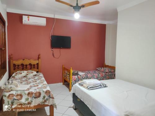 阿瓜斯-迪圣佩德罗Villa Franco的配有两张床铺的客房,墙上配有电视