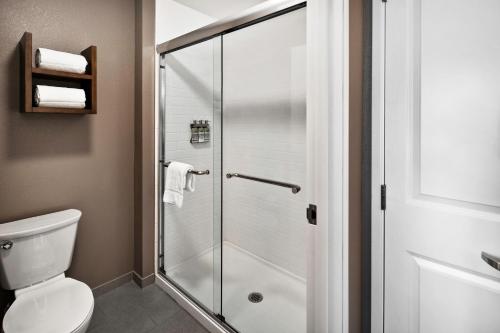 尔湾Staybridge Suites Irvine - John Wayne Airport, an IHG Hotel的设有带卫生间的浴室内的淋浴间
