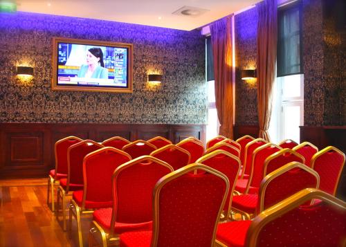 都柏林杰克逊科特酒店的一间设有红色椅子和墙上电视的房间