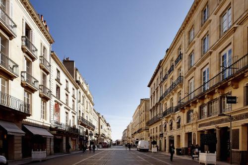 波尔多Maison d'hôtes Bordeaux Centre Le Patio de l'Intendance的街道上,有建筑,人们在街上行走