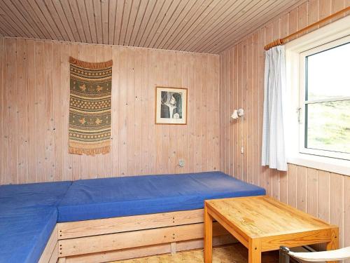 森讷维Two-Bedroom Holiday home in Ringkøbing 9的一间卧室配有蓝色的床和一张木桌