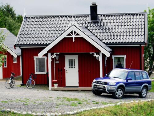 Vevelstad维乐斯德三卧室度假屋的停在红房子前面的一辆蓝色卡车