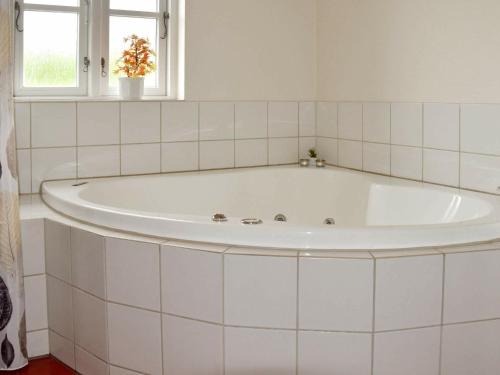 布拉万德Holiday Home Horns Bjerge IV的带窗户的浴室内的白色浴缸