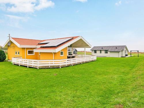 诺德堡8 person holiday home in Nordborg的绿色田野上带太阳能屋顶的房子