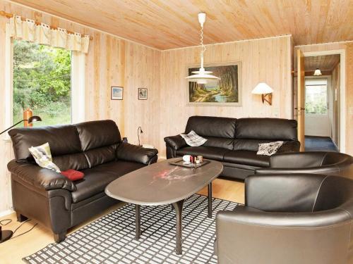 亨讷斯特兰德5 person holiday home in Henne的客厅配有真皮沙发和桌子