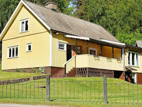 乌拉勒德6 person holiday home in ULLARED的前面有栅栏的黄色房子