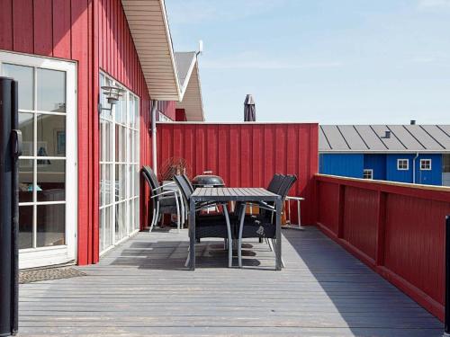 维泽桑讷6 person holiday home in Hvide Sande的红色建筑中带桌椅的庭院