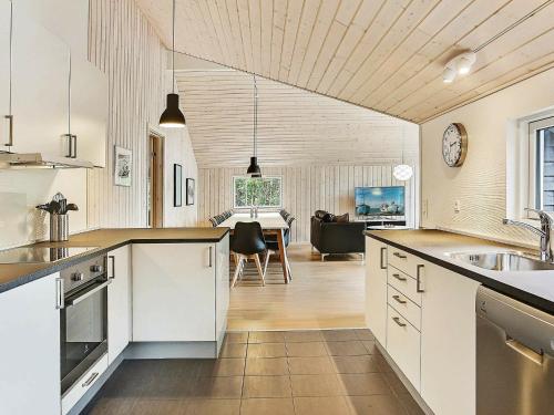 齐斯维勒莱厄Holiday Home Iglekærvej的一间厨房,配有白色橱柜和一间餐厅