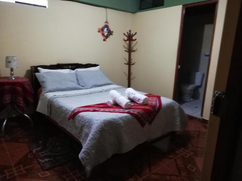 瓦拉斯Artesonraju Hostel Huaraz的一间卧室配有一张床,上面有两条毛巾