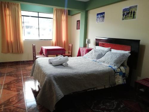 瓦拉斯Artesonraju Hostel Huaraz的卧室里设有一张床,上面有一只动物