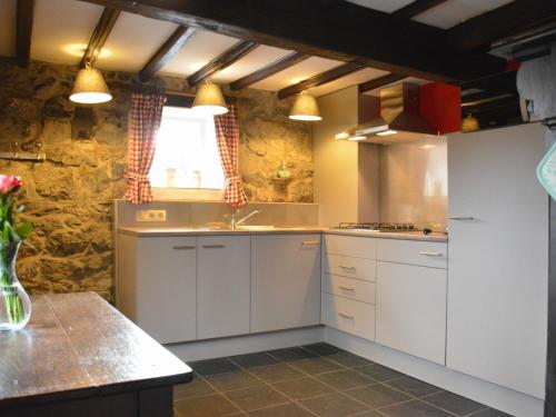 莱斯河畔的汉恩Nice gite with low ceilings in Han sur Lesse的厨房配有白色橱柜、水槽和窗户。