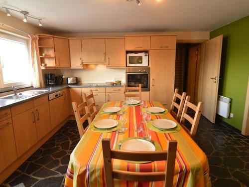 马尔梅迪Detached house with breathtaking views的带长桌和椅子的厨房以及带绿色墙壁的厨房。
