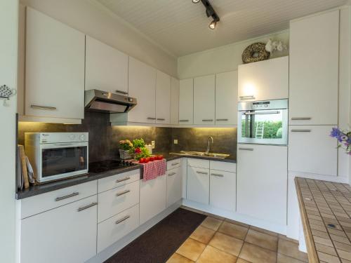ZingemModern Holiday Home in Zingem with Garden的白色的厨房配有白色橱柜和水槽