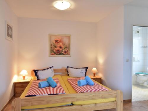 奥斯特巴德里克Delightful Bungalow in Rerik near Baltic Sea Coast的一间卧室配有一张带蓝色枕头的大床